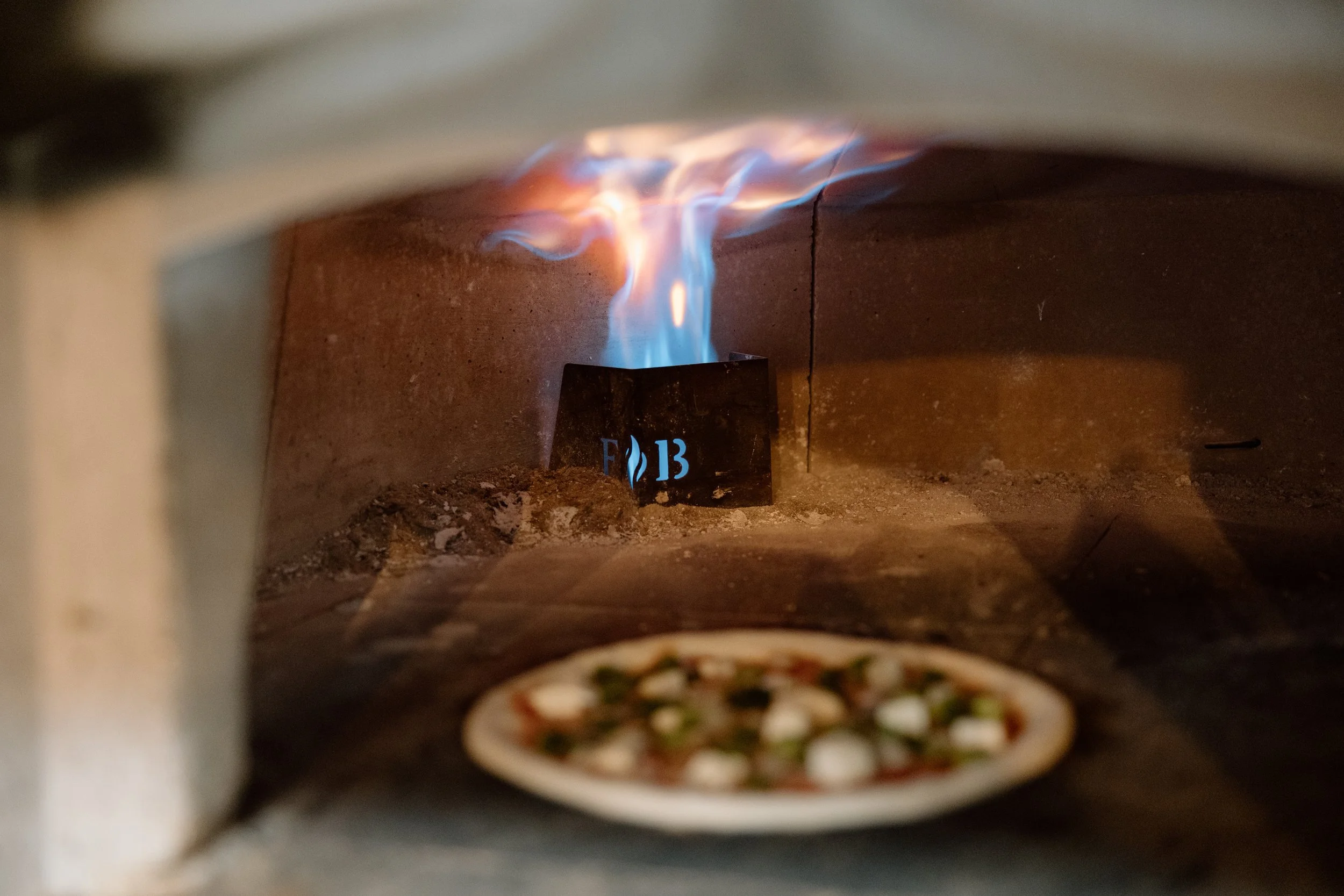 A pizza baking in the Italian brick oven