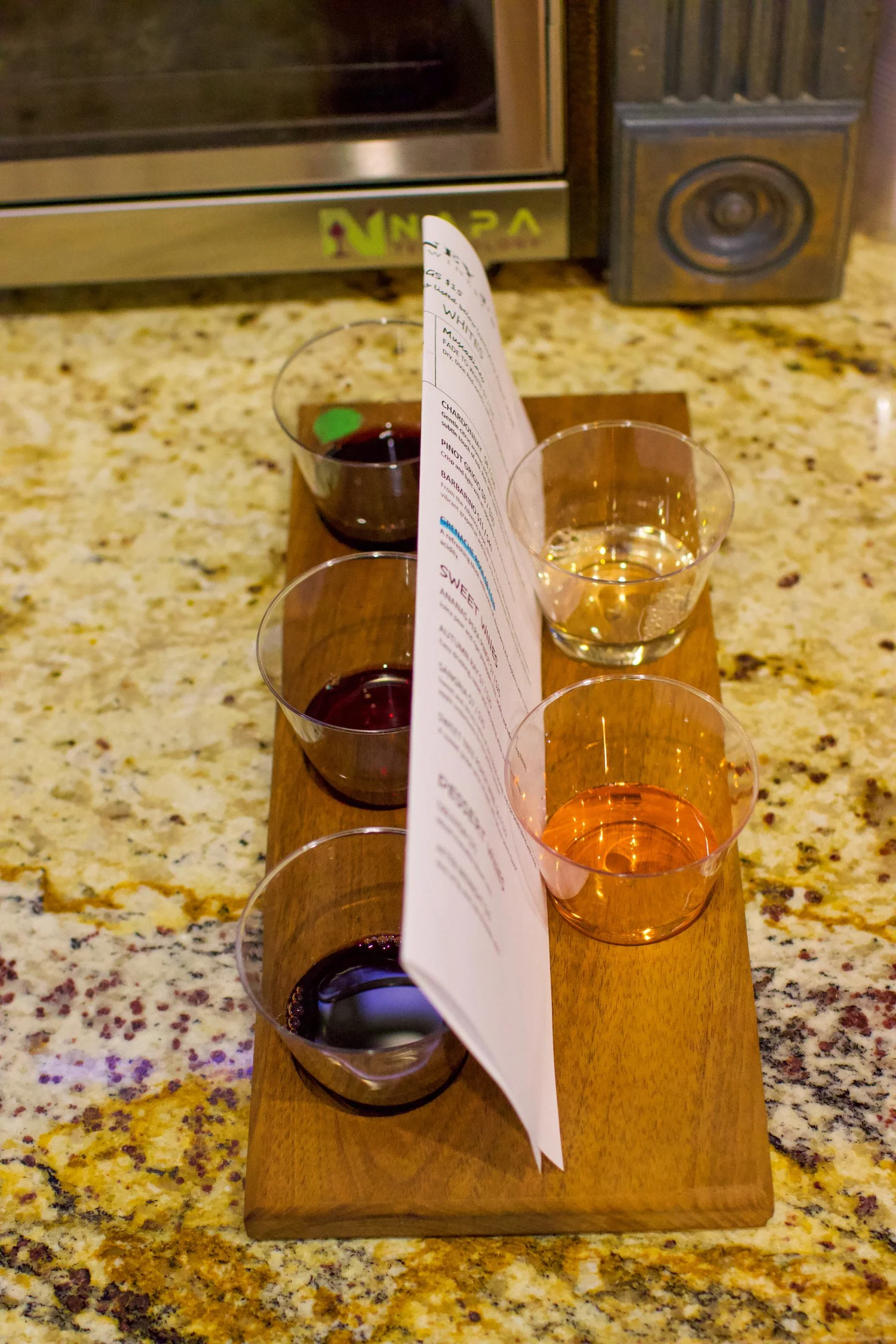 A wine tasting flight on a wooden board